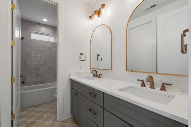 a bathroom with a double vanity sink and mirror with shower