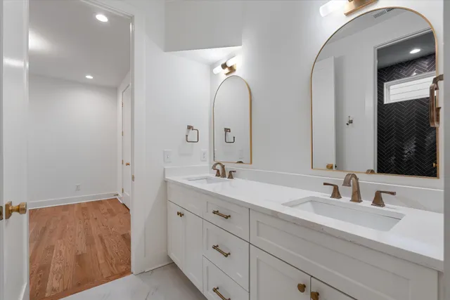 a bathroom with double vanity sink and a mirror