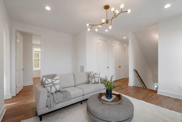 a living room with furniture a chandelier and a potted plant