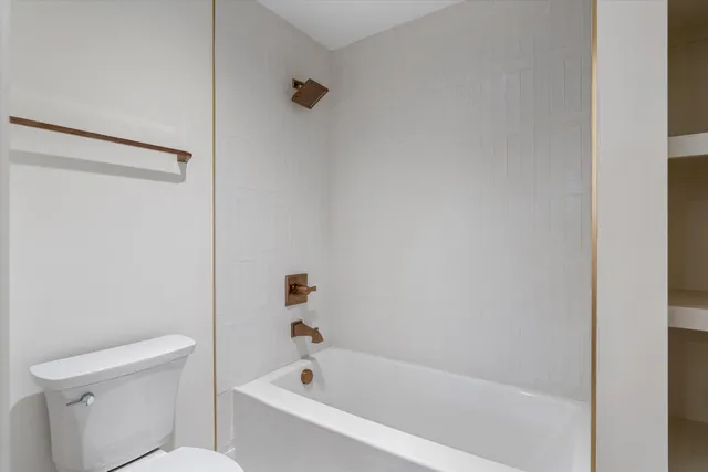 a white bath tub sitting next to a white toilet and sink