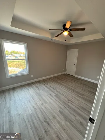 a view of an empty room and window and wooden floor