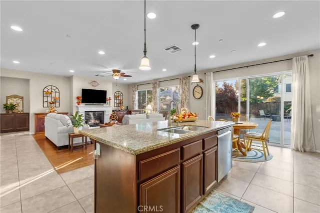 a kitchen with stainless steel appliances granite countertop a stove top oven a sink a dining table and chairs