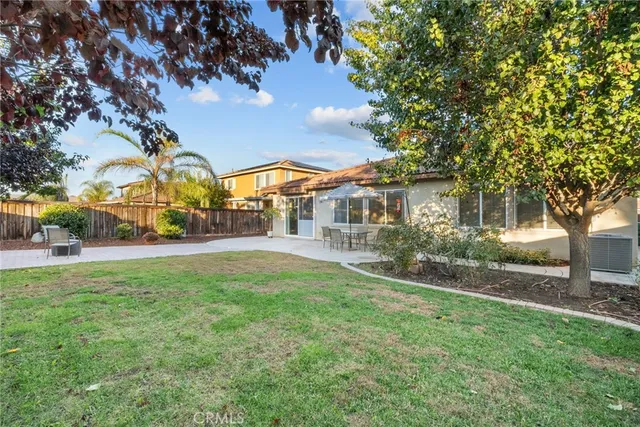 a view of a patio with plants and dining table under an umbrella