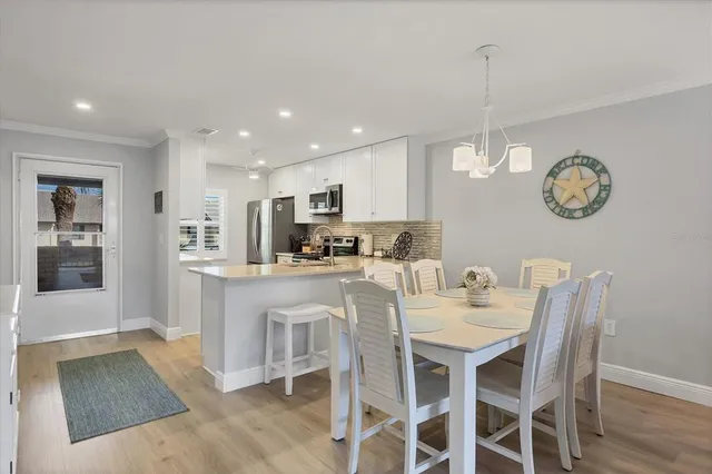 a kitchen with a dining table chairs and cabinets