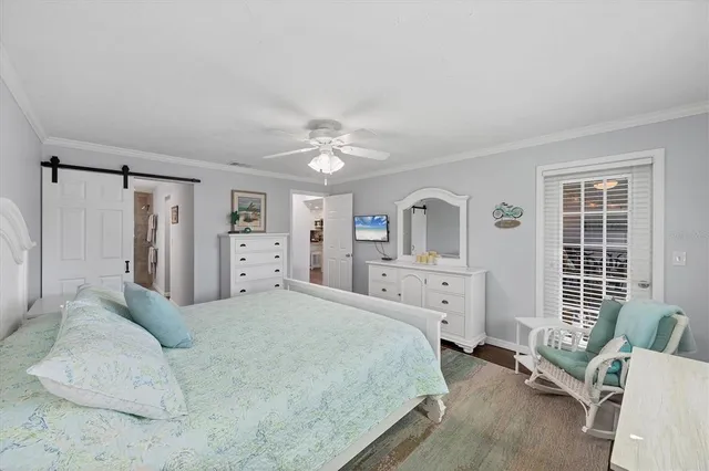 a spacious bedroom with a bed a couch and large window