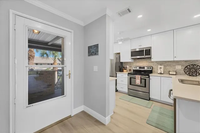 a kitchen with granite countertop a refrigerator and a stove top oven