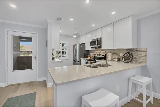 a kitchen with sink a microwave and cabinets