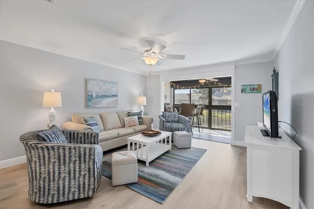 a living room with furniture a lamp wooden floor and a large window