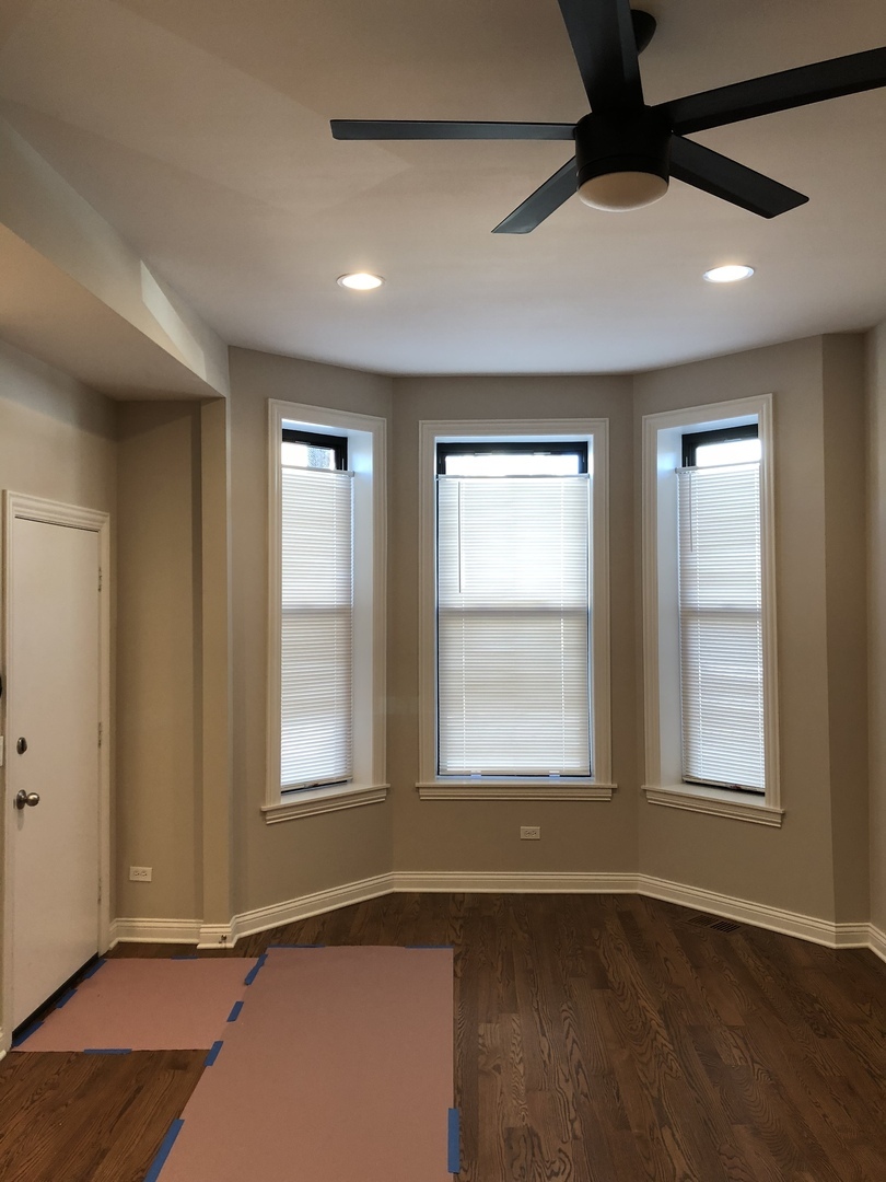 1739 West 18th Street, Unit 1F Chicago, IL 60608 - Photo 4 of 12 an empty room with wooden floor and windows