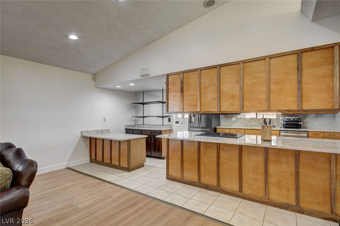 1401 Sharon Road Las Vegas, NV 89106 - Photo 34 of 73 Warm wood cabinetry and durable countertops define this airy culinary space under vaulted ceilings.