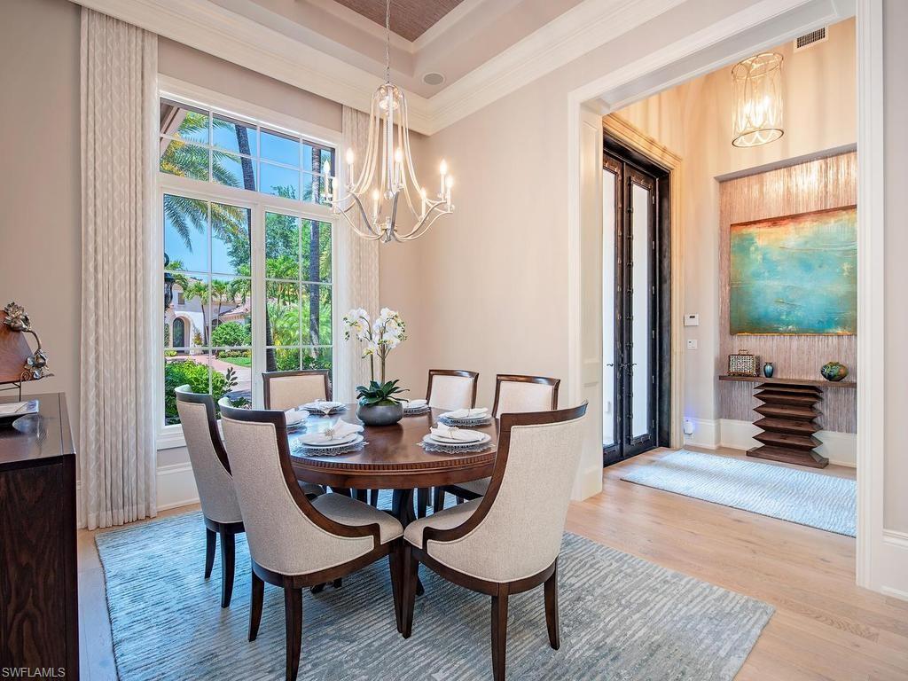 2202 Miramonte Way Naples, FL 34105 - Photo 11 of 23 a dining room with furniture a chandelier and wooden floor