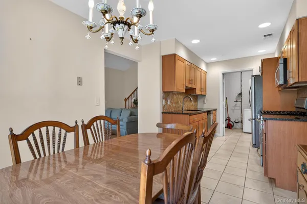 a kitchen with stainless steel appliances a dining table chairs and chandelier