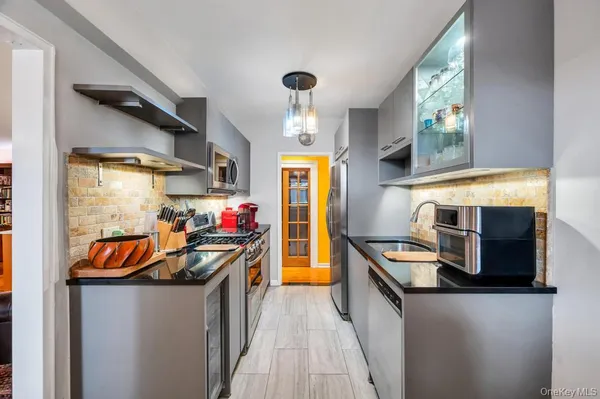 a kitchen with stainless steel appliances a stove a sink and a refrigerator