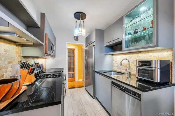 a kitchen with stainless steel appliances a sink a stove and cabinets