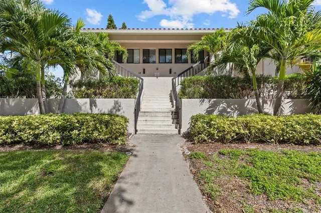 a front view of a house with a yard and potted plants