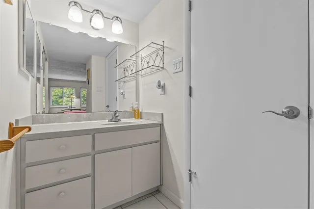 a bathroom with a sink a light fixture and a mirror