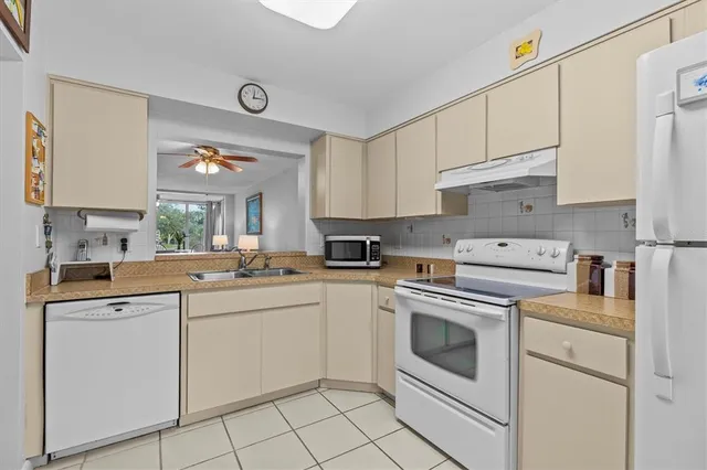 a kitchen with white cabinets appliances and a sink