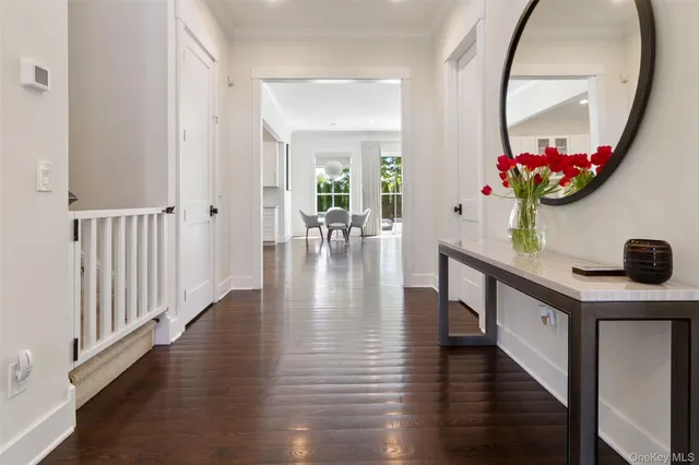 an entryway with wooden floor and a mirror