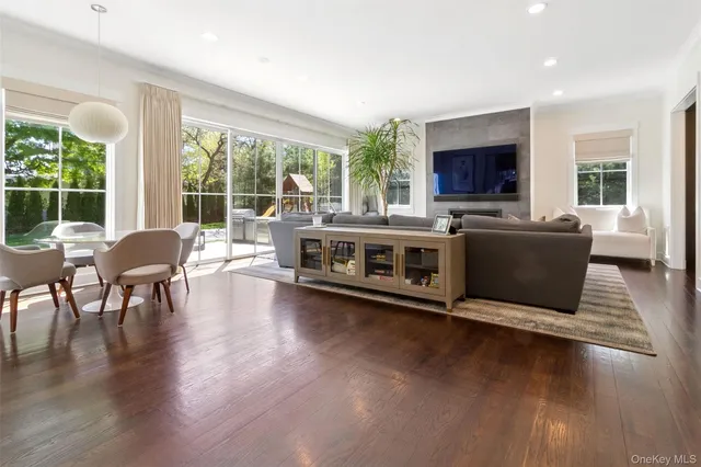 a living room with furniture flat screen tv and a large window
