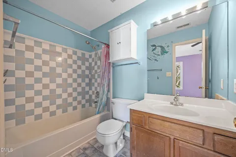 a view of an empty room with window and chandelier fan