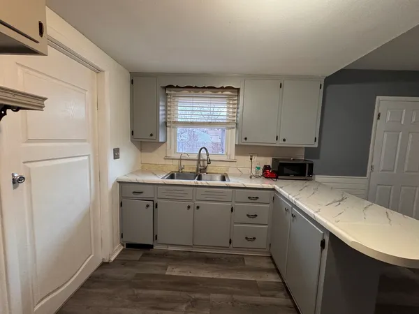 a kitchen with a sink cabinets appliances and a window
