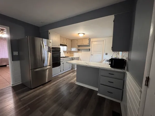 a kitchen with a refrigerator and a stove top oven