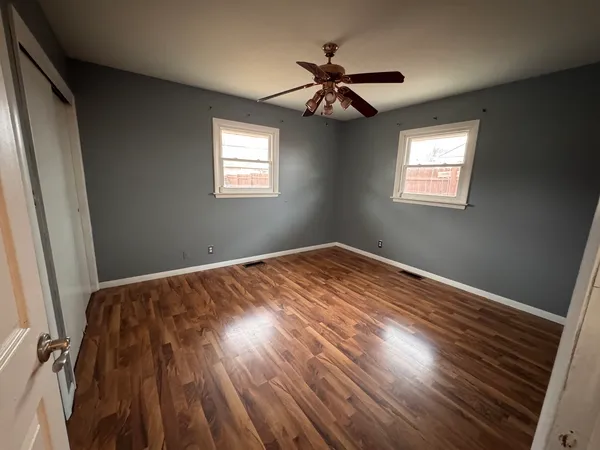 a view of a room with wooden floor and chandelier fan
