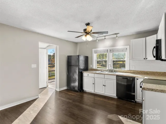 a view of a big room with wooden floor and windows