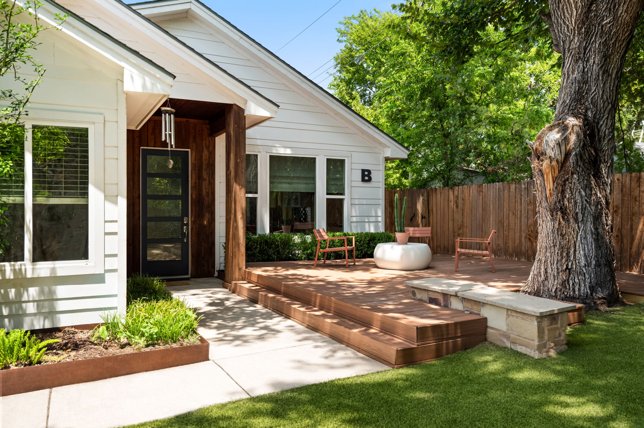 1902 Webberville Road, Unit B Austin, TX 78721 - Photo 35 of 39 A welcoming entry features a stylish modern door and a tiered wood deck, perfect for outdoor relaxation.