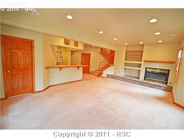7270 Shoup Road Colorado Springs, CO 80908 - Photo 12 of 16 Family room has a fireplace, wet bar, its own spacious bath and easy access to the laundry room. The fourth bedroom/guest suite is on this level too. The family room walks out to a terraced patio.
