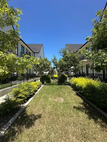 a view of a house with a yard and potted plants