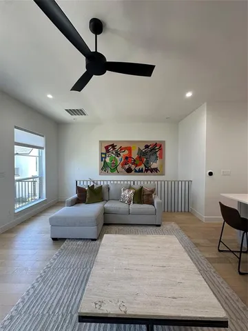 a living room with furniture and a wooden floor