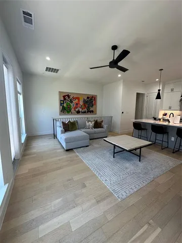 a living room with furniture and a ceiling fan