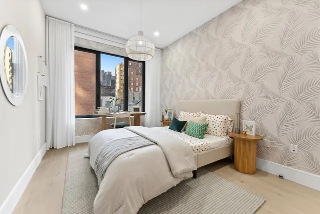 a bedroom with a bed couch and a window