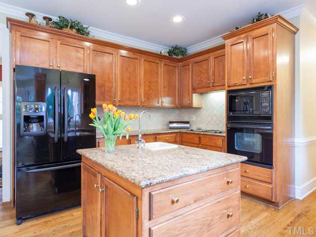 1917 Prescott Place Raleigh, NC 27615 - Photo 7 of 25 Kitchen highlights include granite counter tops, tile back splash, and hardwood floors.