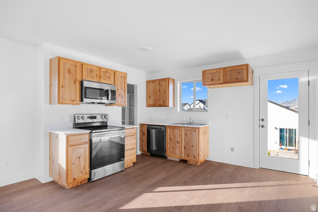 1563 South Deerbrook Road, Unit 267CHM Santaquin, UT 84655 - Photo 6 of 12 Kitchen featuring wood-finish cabinetry, stainless steel appliances, white countertops, and wood-finish flooring