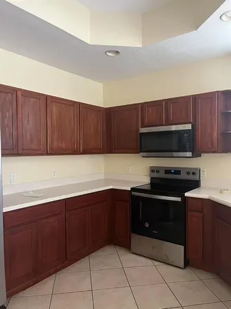 a kitchen with stainless steel appliances granite countertop wooden cabinets a stove top oven and a sink