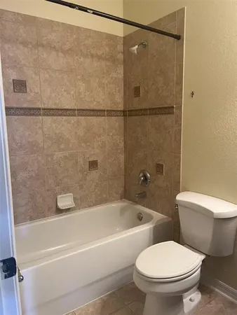 a white toilet and tub sitting next to a bathroom sink