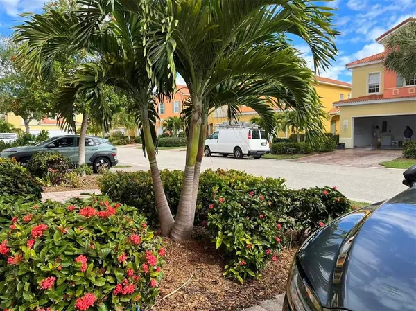 a bunch of flowers in front of yellow house