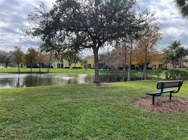a view of a bench in the garden near a lake