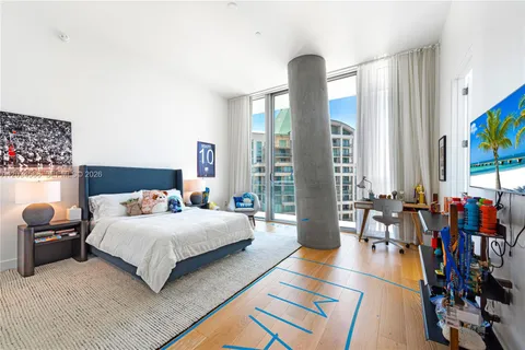 a bedroom with a bed and large window