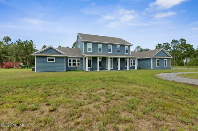 a view of a dining room and livingroom with furniture wooden floor a chandelier