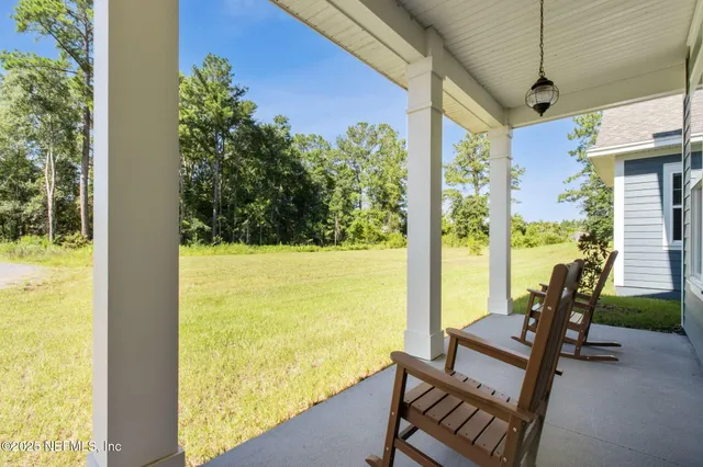 a kitchen with white cabinets and a stove with wooden floor
