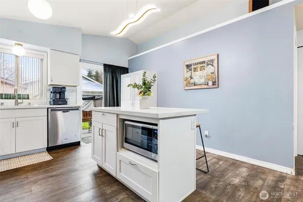a kitchen with stainless steel appliances a stove and white cabinets
