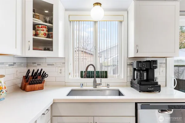a kitchen with sink a window and cabinets