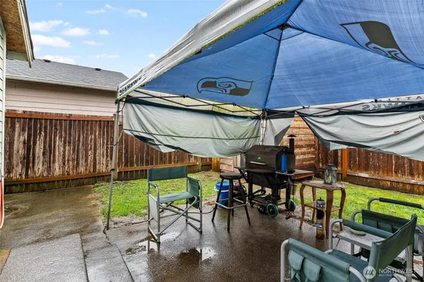 a view of a patio with table and chairs under an umbrella