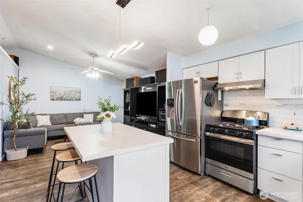 a kitchen with a refrigerator a stove a sink dishwasher and white cabinets with wooden floor