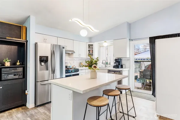 a kitchen with refrigerator and chairs
