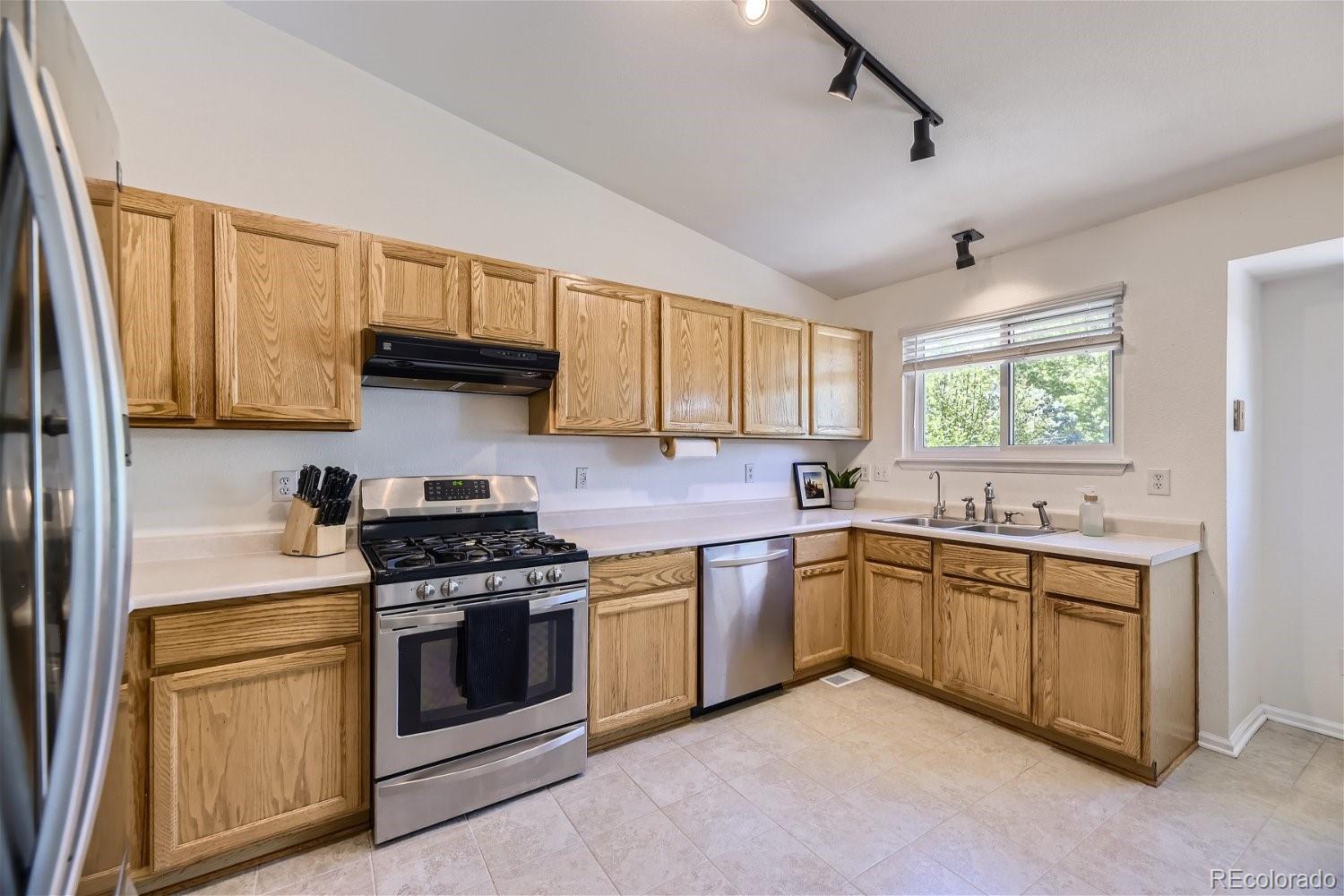 9744 South Castle Ridge Circle Highlands Ranch, CO 80129 - Photo 11 of 28 a kitchen with stainless steel appliances granite countertop a stove sink and cabinets