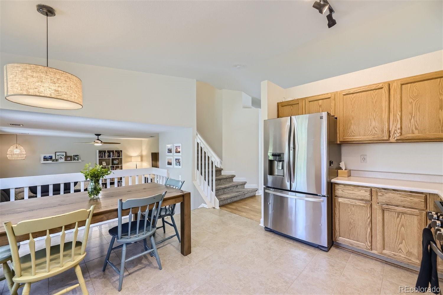 9744 South Castle Ridge Circle Highlands Ranch, CO 80129 - Photo 14 of 28 a kitchen with stainless steel appliances granite countertop a refrigerator and a dining table